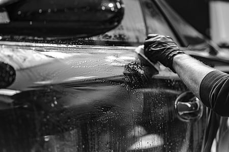 person with gloves holding cloth against car thumbnail