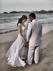 newly wed couples beside seashore under gray clouds during daytime thumbnail