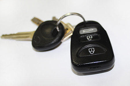 black and gray vehicle fob and keys on white surface thumbnail