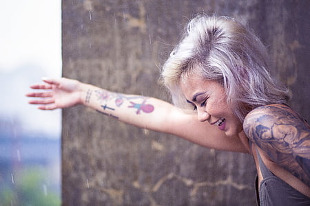 woman wearing gray top beside brown wall thumbnail