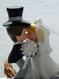 man and woman kissing figurine near white wal thumbnail