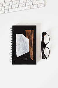 flat lay photography of textbook and eyeglass thumbnail