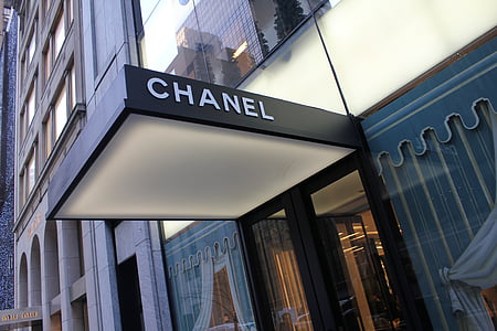 low-angle photography of grey and beige Chanel signage at daytime thumbnail