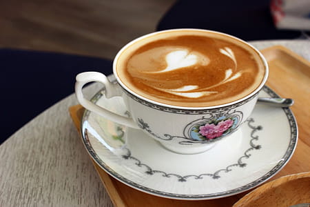 Hot Latte Coffee with Heart Art in a Classical Porcelain Cup and Saucer thumbnail