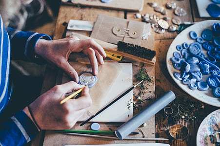 person carving round white ornament on top of wooden table thumbnail