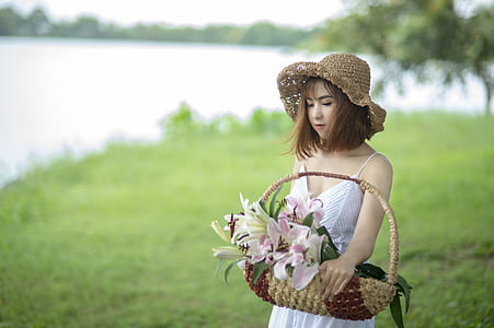 Woman in White Spaghetti Dress Holding Basket thumbnail
