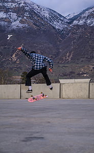 person kick flip skateboard with mountain background thumbnail