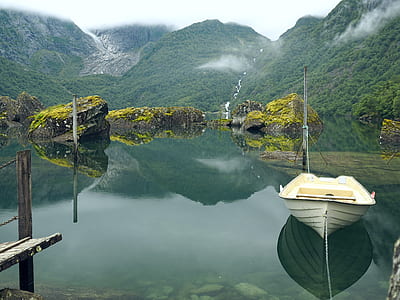 white row boat near the mountain thumbnail