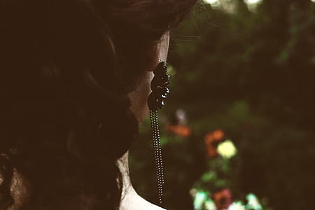 Selective Focus Photography of Woman's Back With Black Pendant Earrings thumbnail