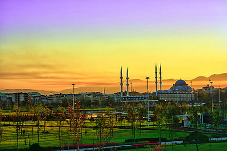mosque near houses under purple and orange sky thumbnail