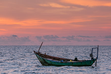 teal boat on sea at golden hour thumbnail