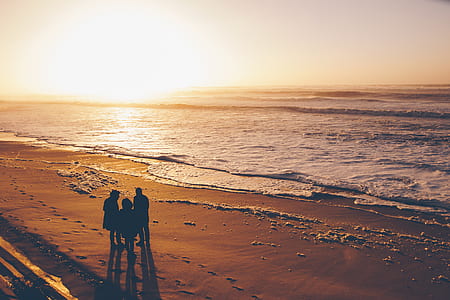three persons standing near beach shoreline thumbnail