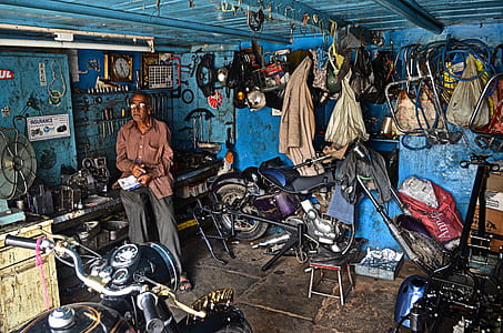 man sitting on work table inside garage thumbnail