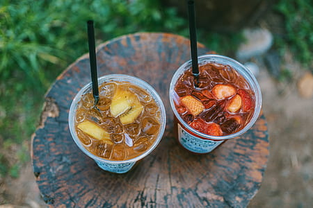 Selective Focus Photo of Two Juice Filled Plastic Cups thumbnail
