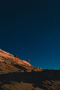 man standing on mountain during daytime thumbnail