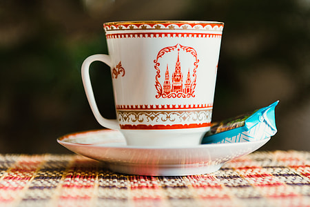 white and red ceramic mug on saucer thumbnail