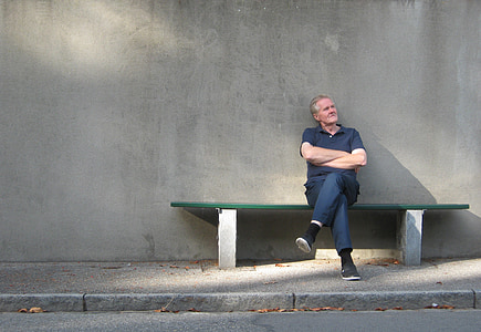 man in polo shirt sitting on bench thumbnail