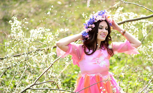 woman wearing pink dress and flower headdress beside tree branch thumbnail