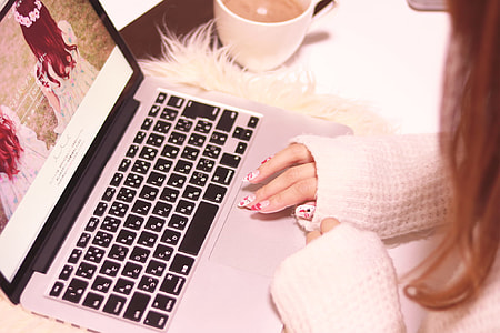 woman wearing white sweater using laptop thumbnail