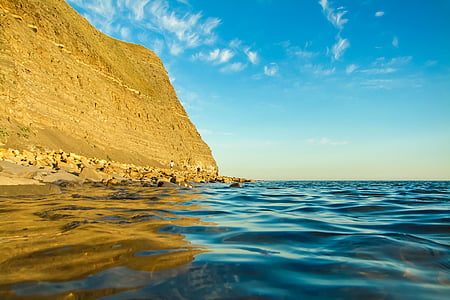 body of water beside mountain thumbnail