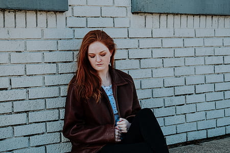 woman sitting on gray concrete brick wall during daytime thumbnail
