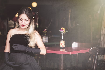 woman wearing black dress beside red table thumbnail