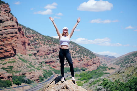 woman standing on gray stone near cliff thumbnail
