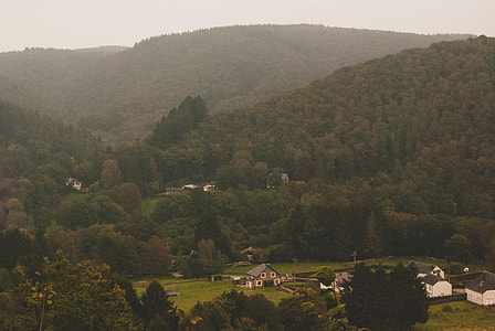 white and gray house in between of mountains during daytime thumbnail