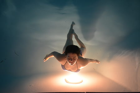 woman swimming in pool with lamp at bottom thumbnail