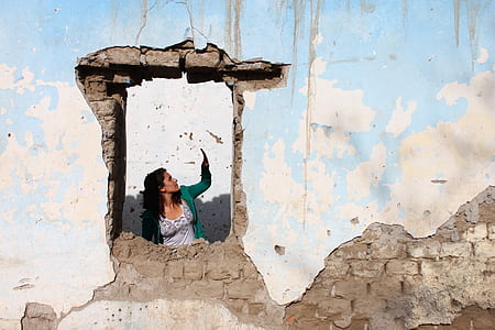 minimalist photography of woman leaning on concrete window thumbnail