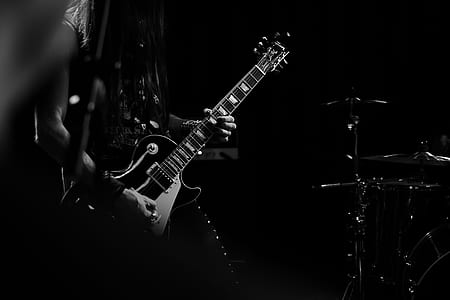 grayscale photography of person holding stratocaster guitar thumbnail
