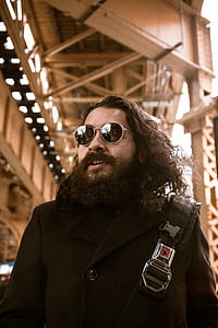 bearded man in black coat and wearing black sunglasses thumbnail