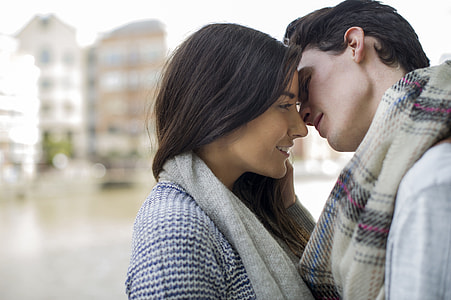 man in purple and brown scarf going to kiss woman beside river thumbnail