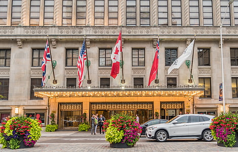 white SUV infront of brown building thumbnail