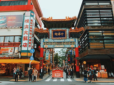 people beside buildings under blue gate during daytime thumbnail