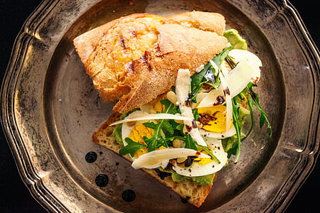 toasted bread with sliced egg and fresh vegetables on copper-colored plate thumbnail