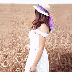 woman standing near wheat field during daytime thumbnail
