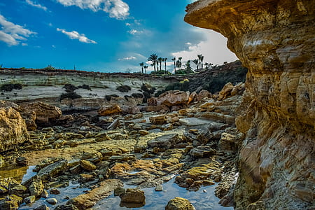 cliff with water under cloudy sky thumbnail