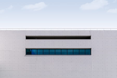 white concrete building with blue glass windows thumbnail