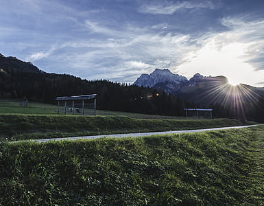 gray metal frames on green grass field near mountains thumbnail