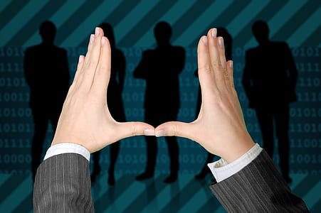 person's hand with silhouette of people in background thumbnail