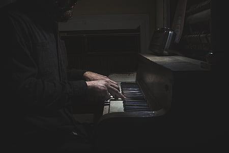 man sitting beside piano thumbnail