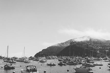 boats on body of water near mountain thumbnail