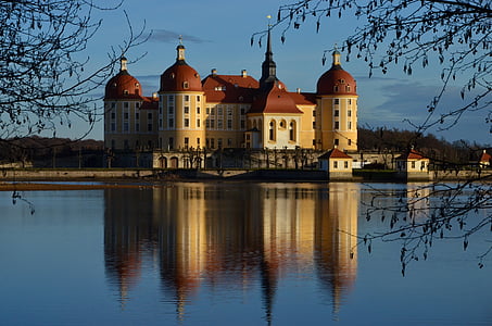 yellow and red concrete building near body of water thumbnail