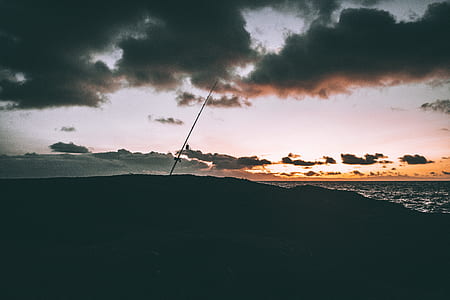 silhouette of hill under clouds thumbnail