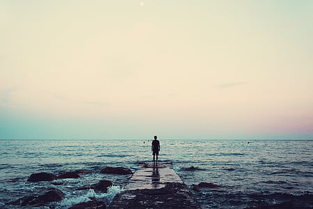 person standing on dock near body of water thumbnail