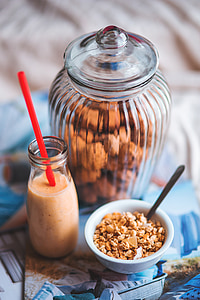 clear glass jar beside clear glass bottle filled with brown liquid and food in bowl thumbnail