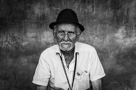 grayscale photo of man wearing polo shirt and hat thumbnail