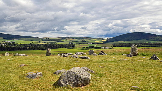 plain grass field with stones overlooking mountain under clear blue sky thumbnail