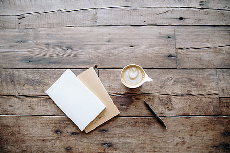 white ceramic mug beside pen and paper thumbnail